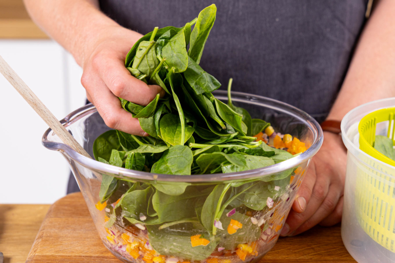 Spinat waschen, schleudern und zum restlichen Salat geben