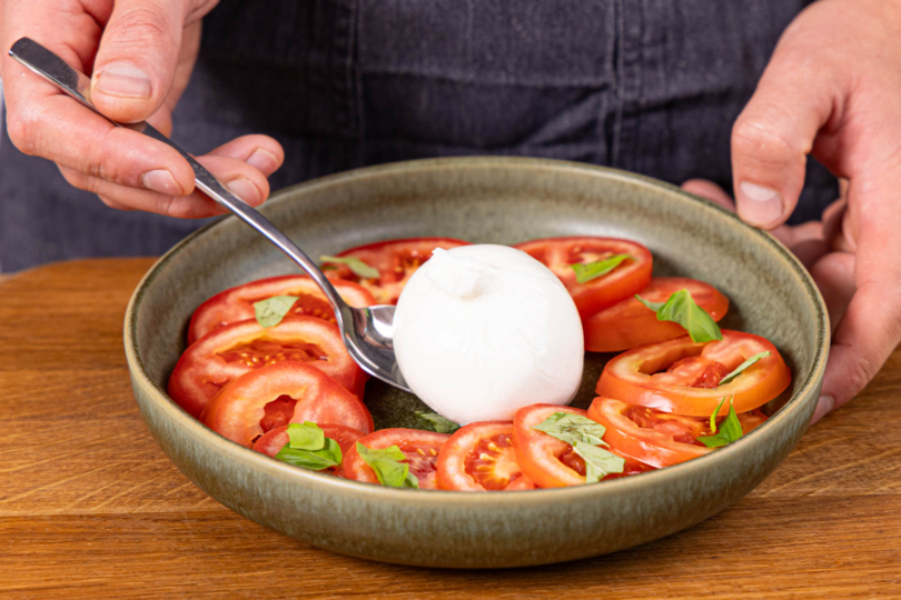 Burrata auf den Teller legen