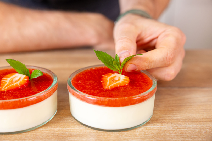Erdbeer-Panna Cotta Dessert im Glas garnieren