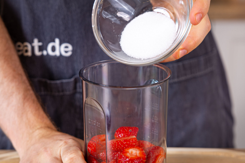 Zucker zu den Erdbeeren geben