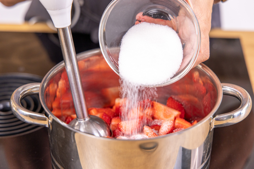 Zucker zu den Erdbeeren geben