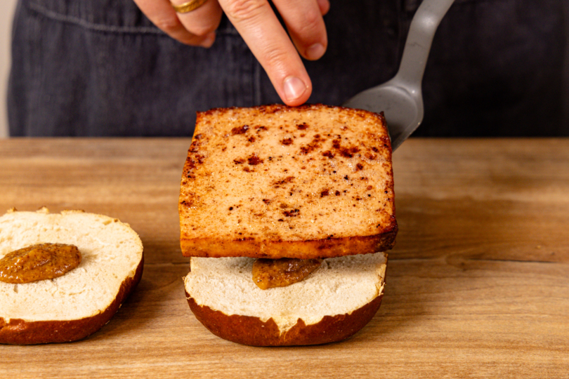 Fleischkäse auf Laugenbrötchen setzen
