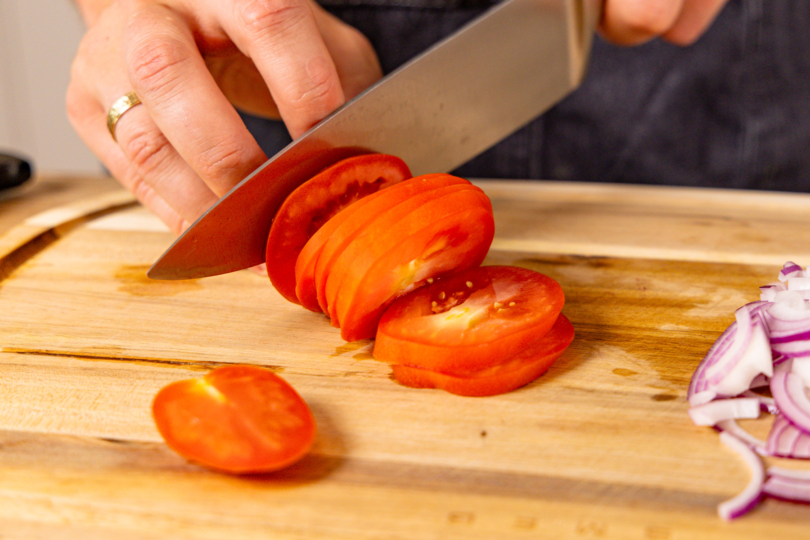 Tomate in dünne Scheiben schneiden