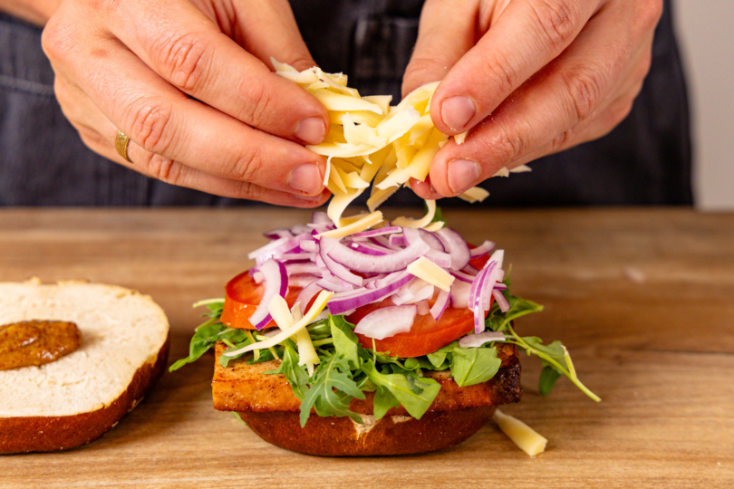 rote Zwiebeln und geriebenen Gouda auf den Laugenburger schichten