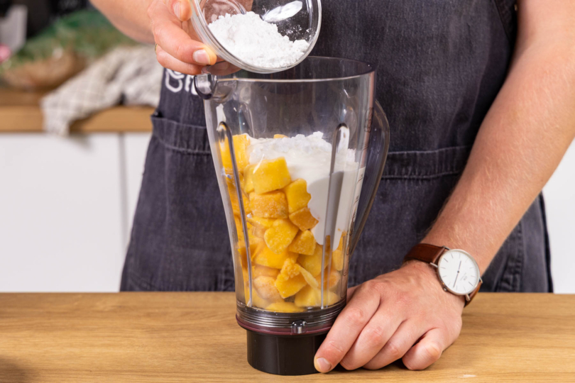 Puderzucker und Joghurt zur Mango