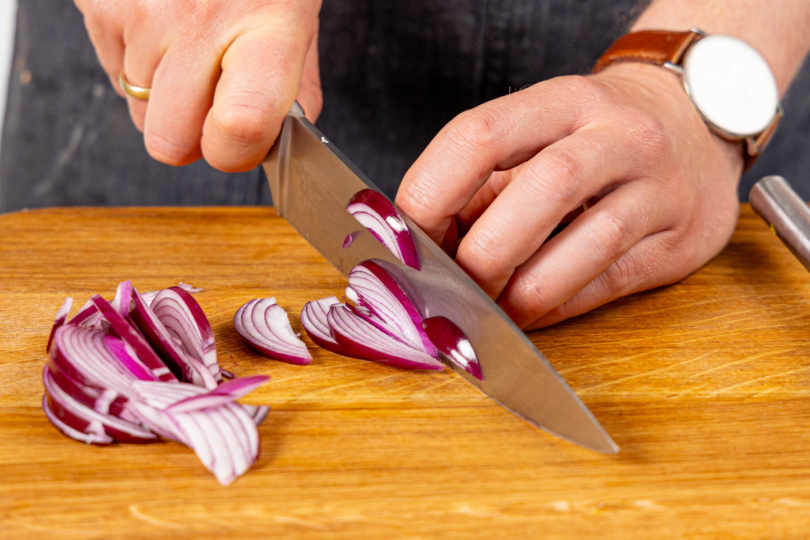 Rote Zwiebel in dünne Streifen schneiden