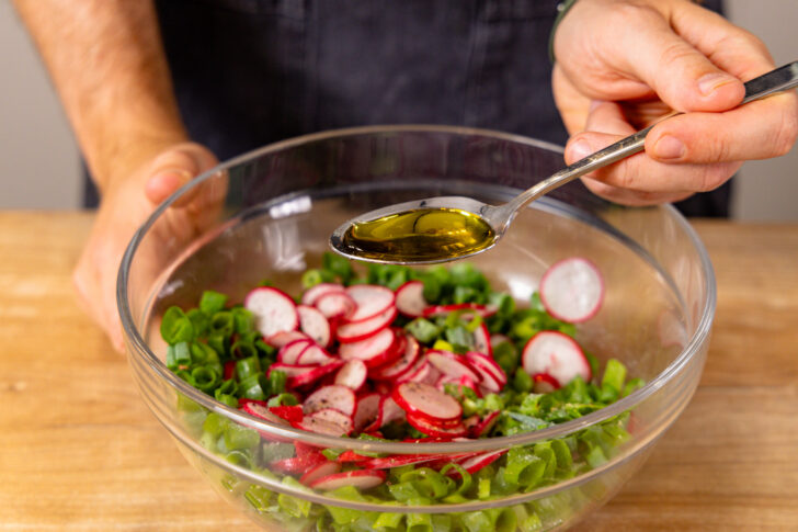 Olivenöl zum Radieschensalat geben