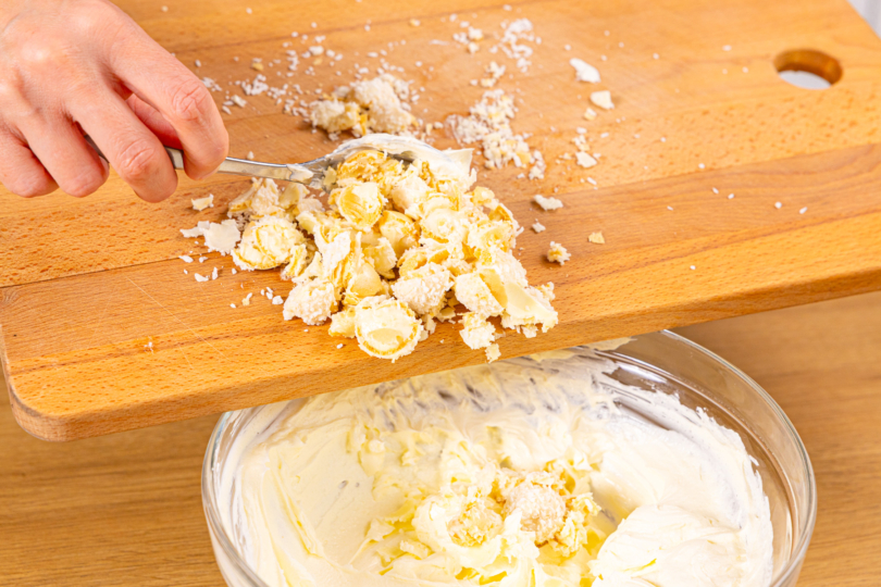 Zerkleinerte Raffaello® in Creme geben
