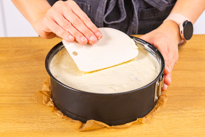 Tortencreme auf Keksboden verstreichen