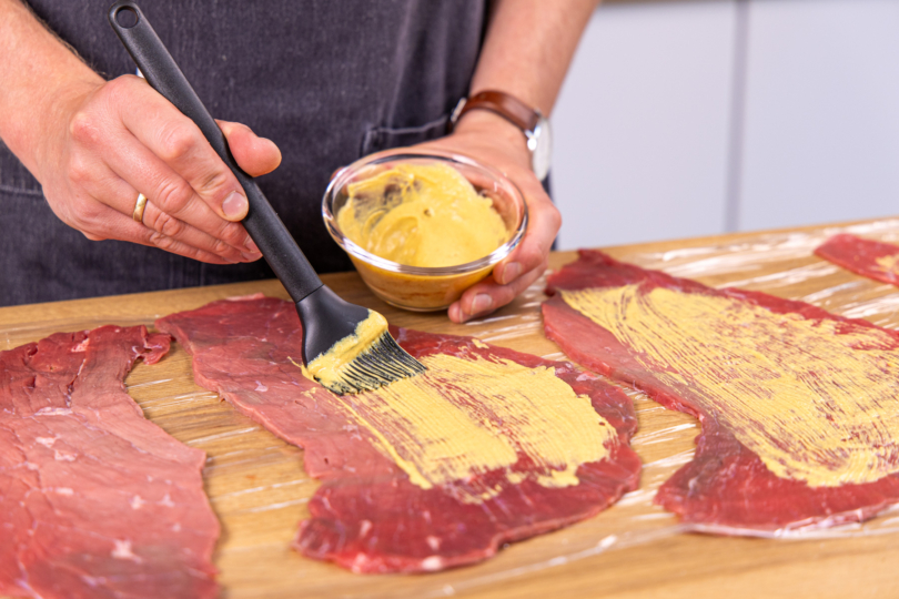 Rouladen mit Senf bestreichen