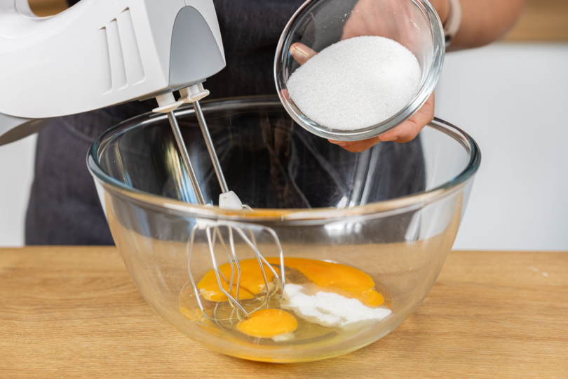Zucker und Eier aufschlagen