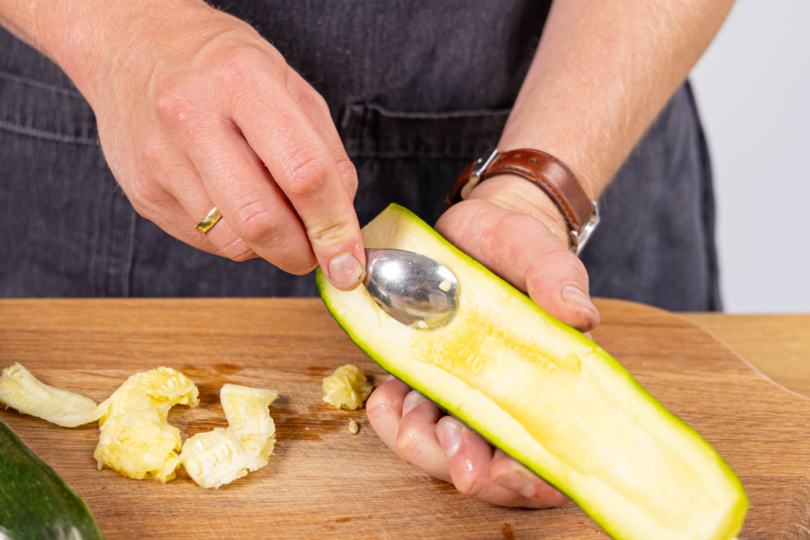 Kerngehäuse mit einem Löffel aus den Zucchini kratzen