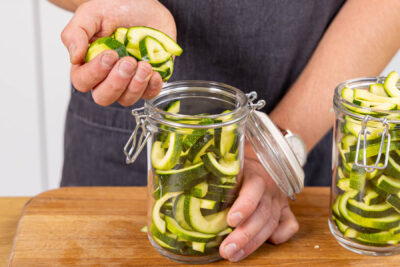 Zucchini in Scheiben schneiden und in Gläser geben