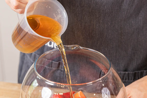 Apfelsaft in das Gefäß füllen, für die Silvester-Kinderbowle