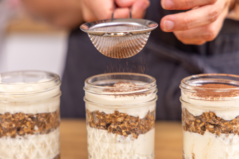 Tiramisu Overnight Oats mit Backkakao bestäuben