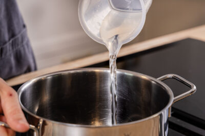 Wasser in den Topf geben