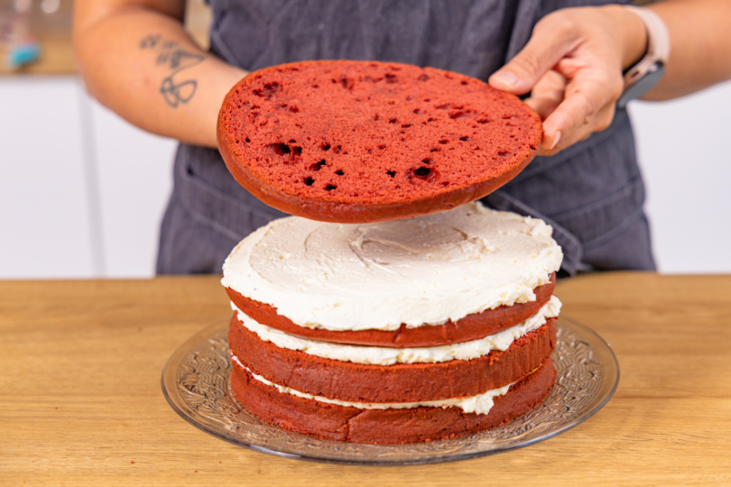 Red-Velvet-Böden und Tortencreme abwechselnd schichten