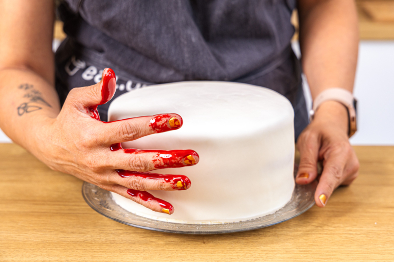 Handabdruck mit essbarem Blut auf der Torte machen