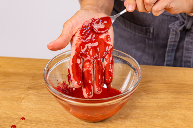 essbares Blut auf der Hand verstreichen