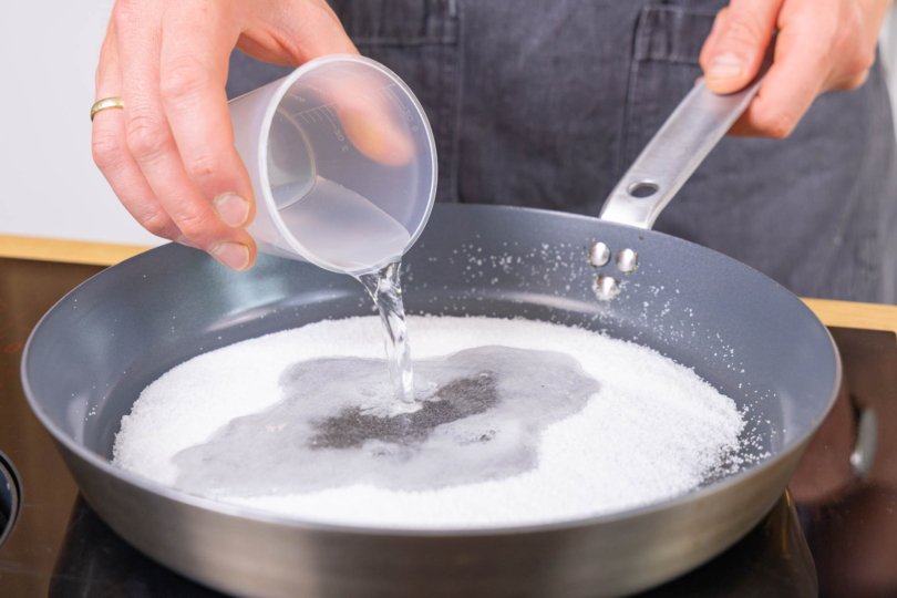 Wasser in die Pfanne gießen