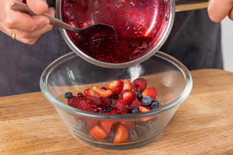 Beerensauce mit frischen Beeren mischen