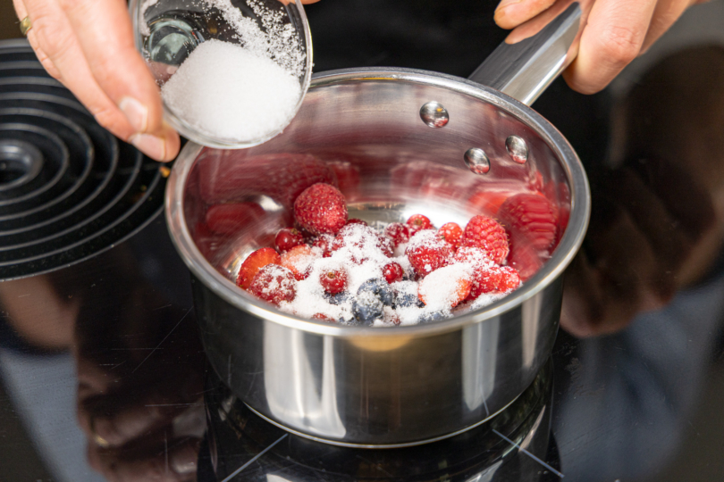 Zucker zu den Beeren geben
