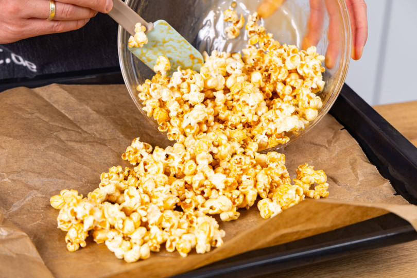 Popcorn auf das Backblech geben.
