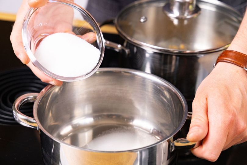 Zucker in den Topf geben.