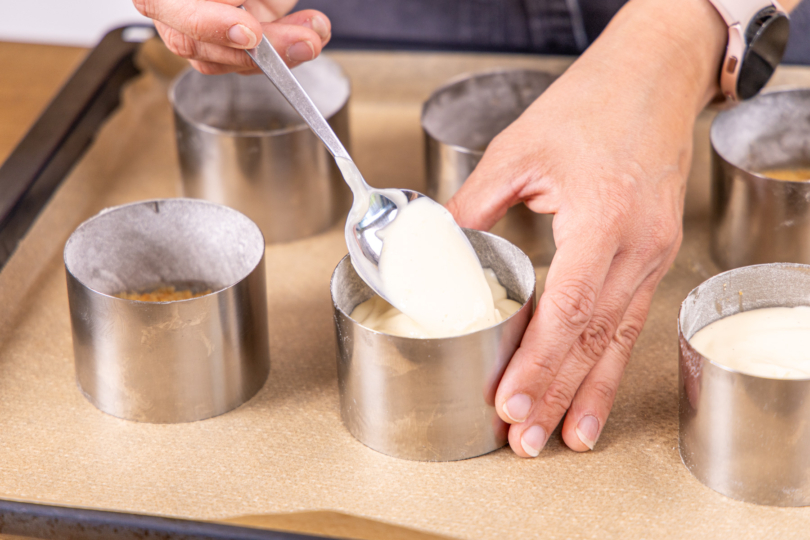 Käsekuchen-Masse in die Förmchen füllen