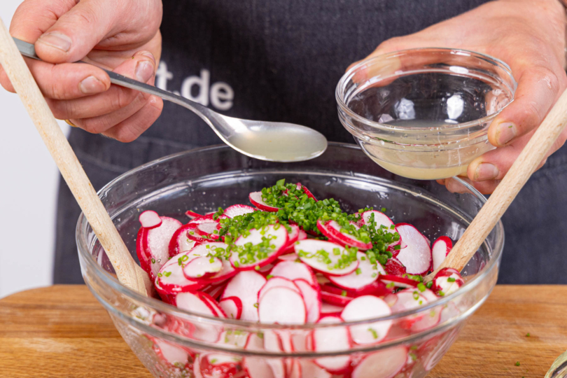 Salat mit Öl und Zitronensaft abschmecken