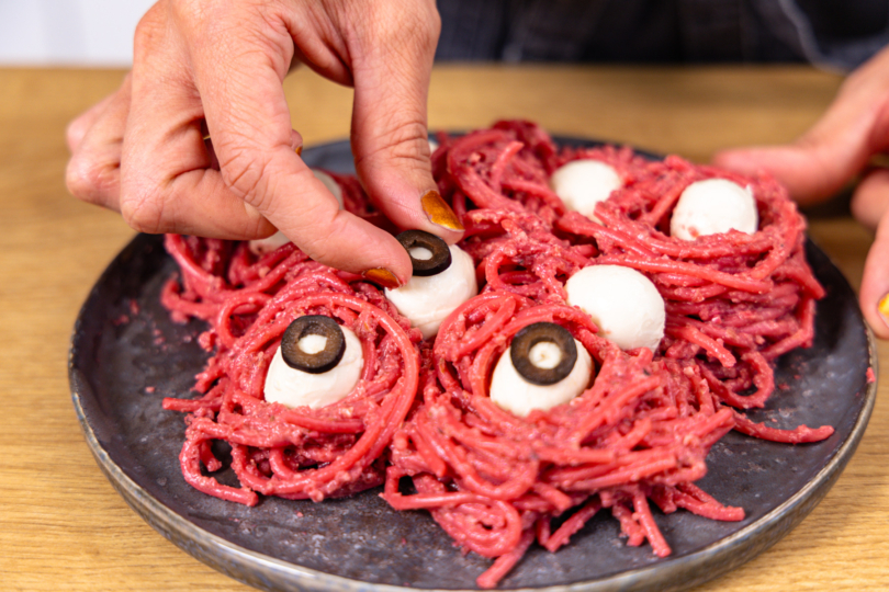 Olivenringe auf den Mozzarellakugeln platzieren