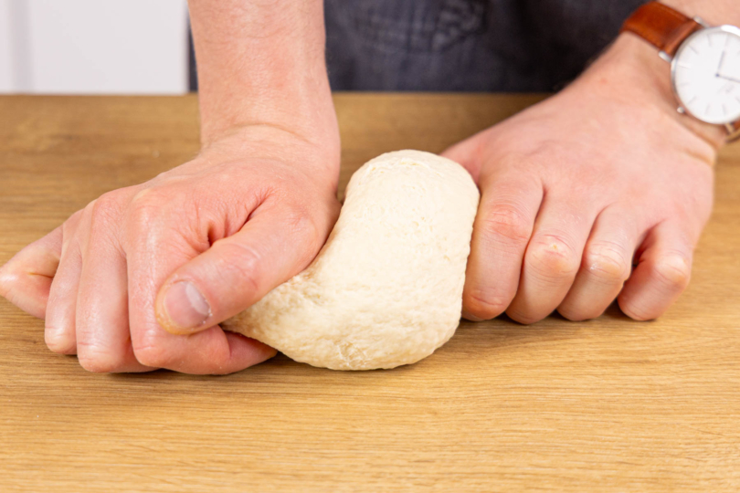 Flammkuchenteig per Hand nachkneten und ruhen lassen