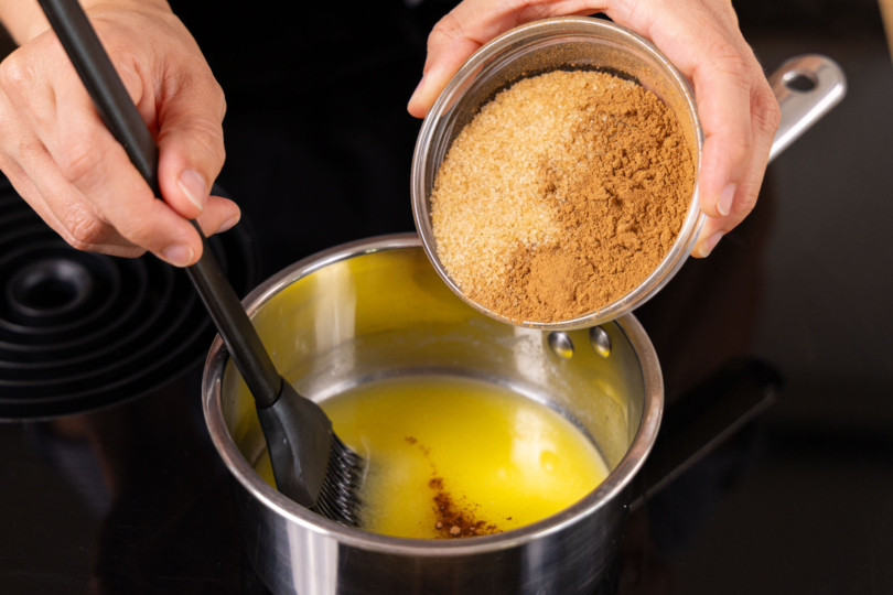 Zucker und Zimt in Butter geben