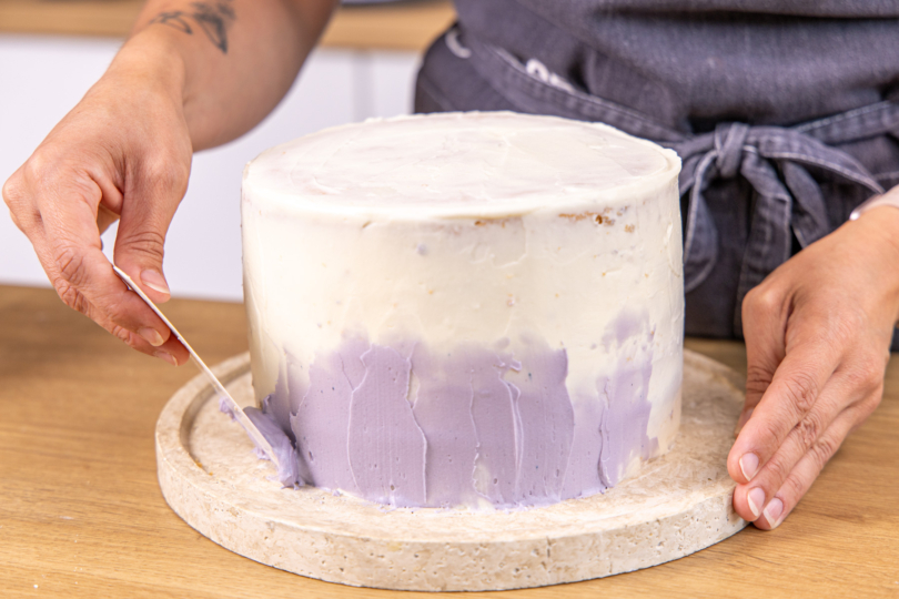 Zitronen-Lavendel-Torte mit der violettem Creme einstreichen