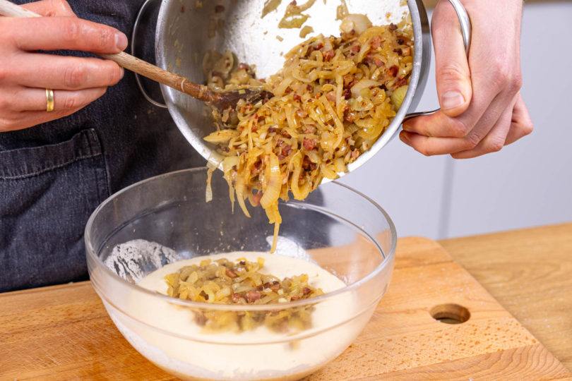 Zwiebeln und Speck mit Eiermasse verrühren