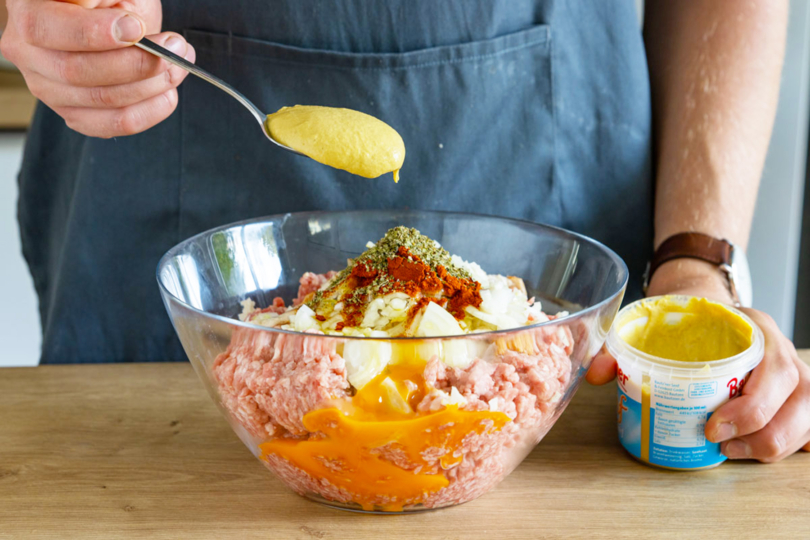 Senf in die Schüssel zum Hackfleisch geben
