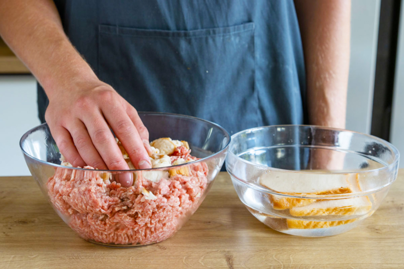in Wasser aufgeweichtes Toast zum Hackfleisch geben