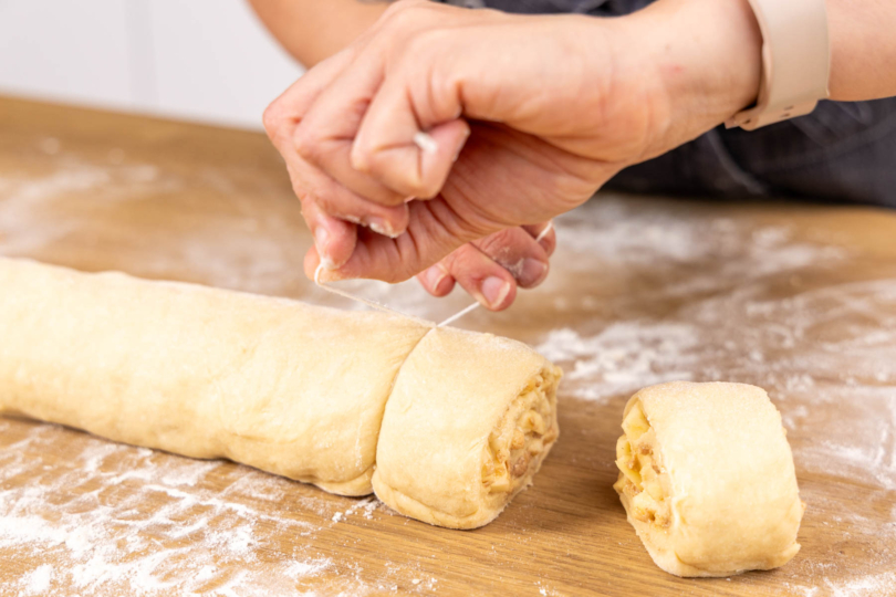 Apfel-Zimtschnecken von Teigrolle abtrennen