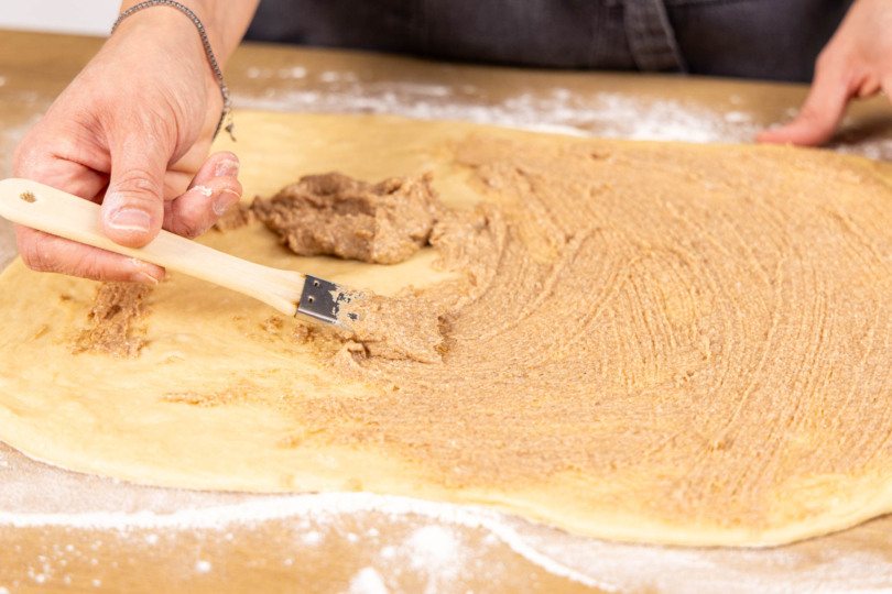 Hefeteig mit der Füllung bestreichen