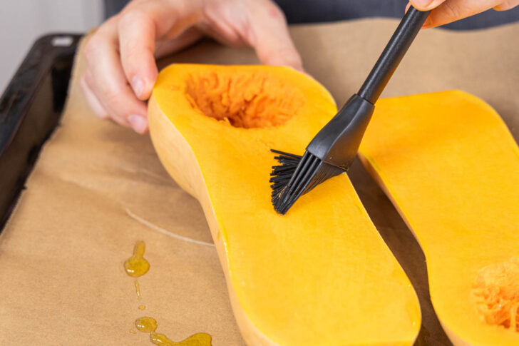 Kürbis mit Olivenöl bestreichen, für gefüllter Butternut-Kürbis mit Spinat und Feta