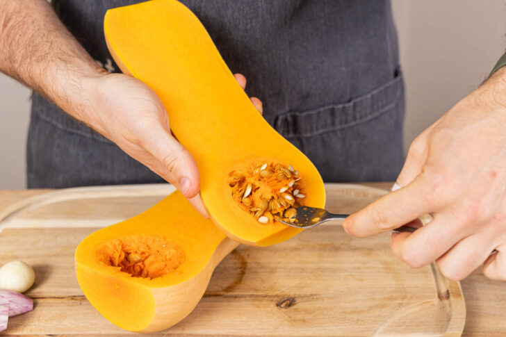Butternut-Kürbis mit einem Löffel aushöhlen, für gefüllter Butternut-Kürbis mit Spinat und Feta