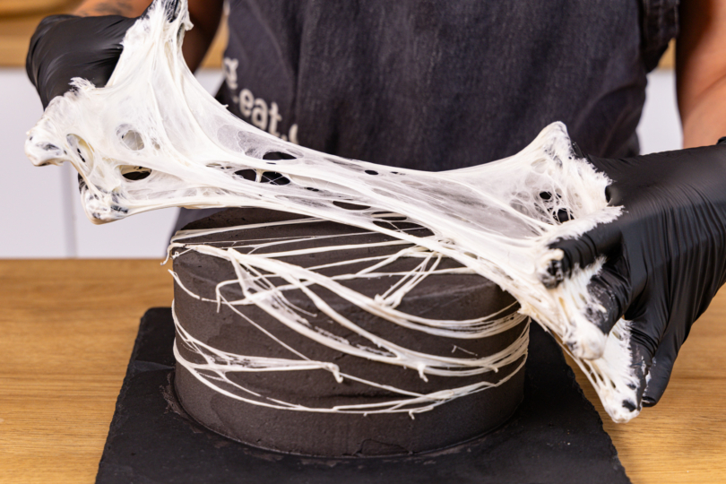 Marshmallows zwischen den Finger zu Spinnenetz ziehen