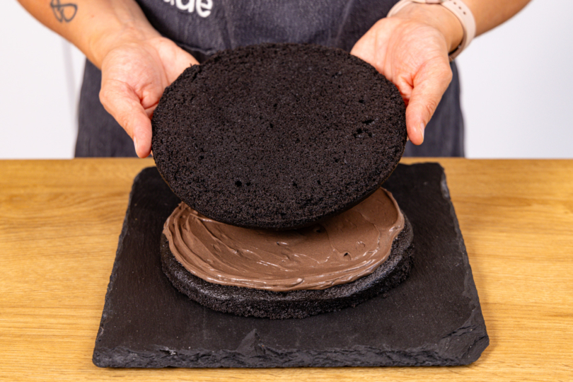 Zweiten Boden auf cremebedeckten ersten Boden legen