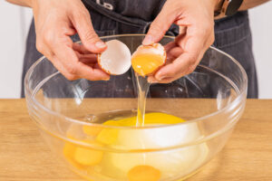 Eier in eine Schüssel geben