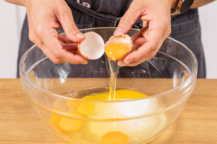 Eier in eine Schüssel geben