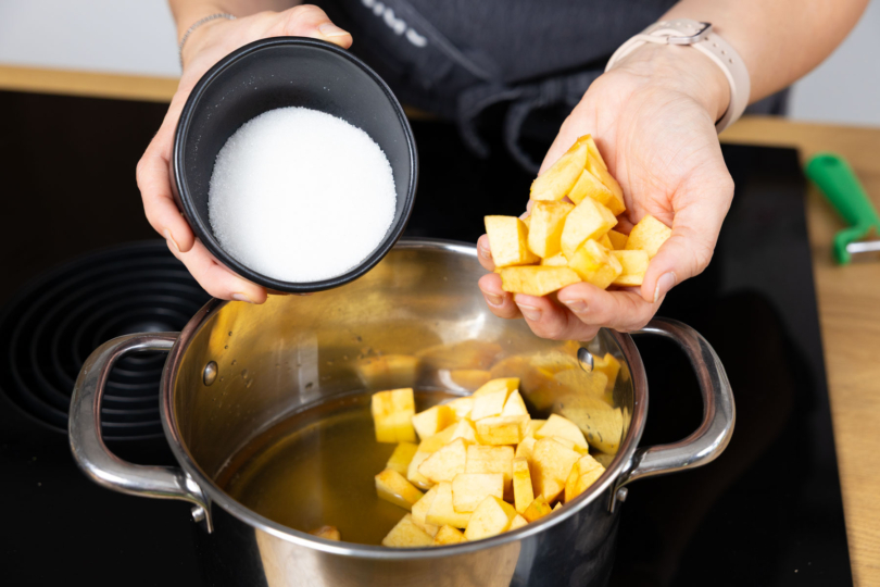 Quitten und Zucker in Topf geben