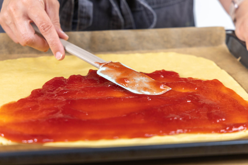 mit Marmelade bestreichen