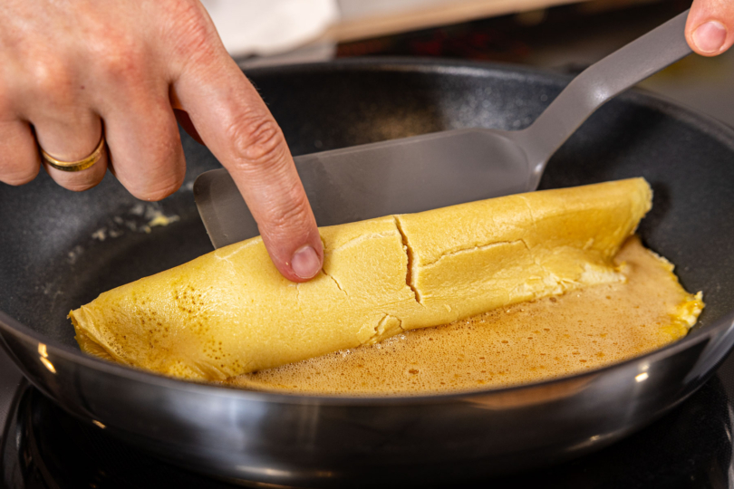 Omelette in der Pfanne einklappen und aufrollen