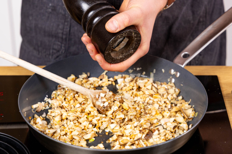 Schalotten, Knoblauch und Kräuterseitlinge anbraten