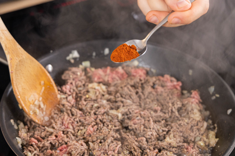 Paprikapulver zum Hackfleisch geben